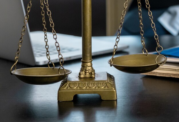 Office of Lawyer with Scales, laptop and documents on the workplace.