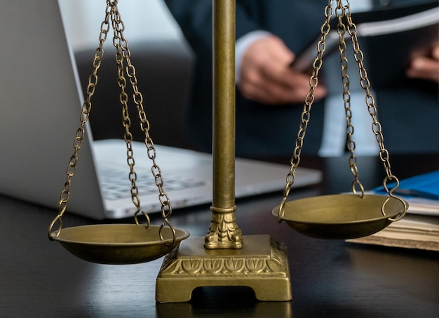 Office of Lawyer with Scales, laptop and documents on the workplace.