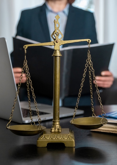 Office of Lawyer with Scales, laptop and documents on the workplace.