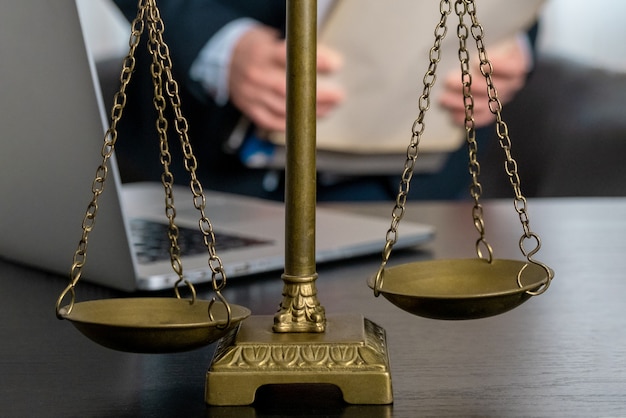 Office of Lawyer with Scales, laptop and documents on the workplace.