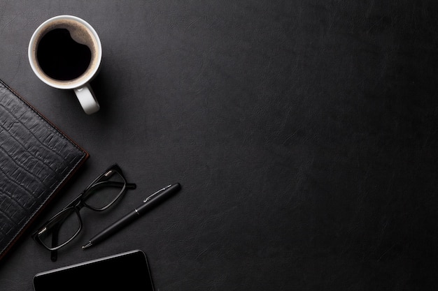 Office leather desk table with coffee and supplies