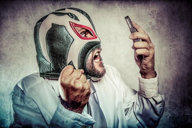 Office man arguing by phone, aggressive executive suit and tie, Mexican wrestler mask