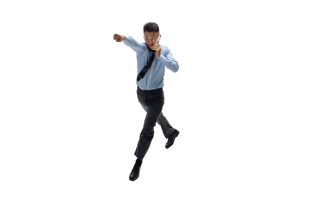 Office man practicing taekwondo on white wall