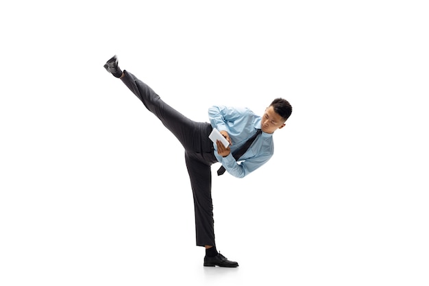 Office man practicing taekwondo on white wall