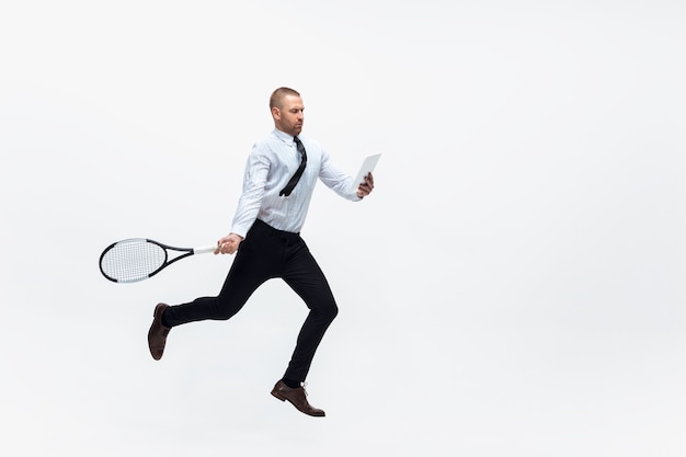 Office man speelt tennis op witte studio achtergrond