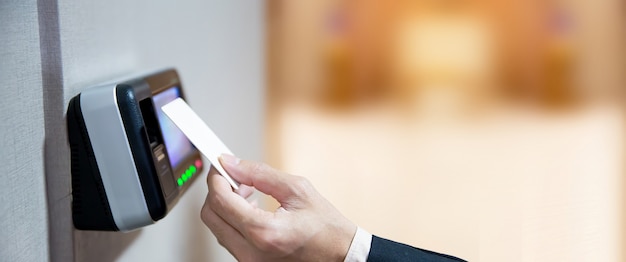 Office man using the id card to scan at the access control.