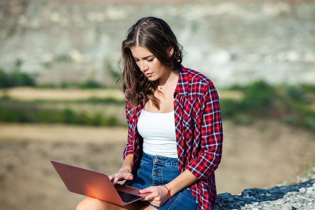 Office outdoors. Girl freelancer work typing on laptop