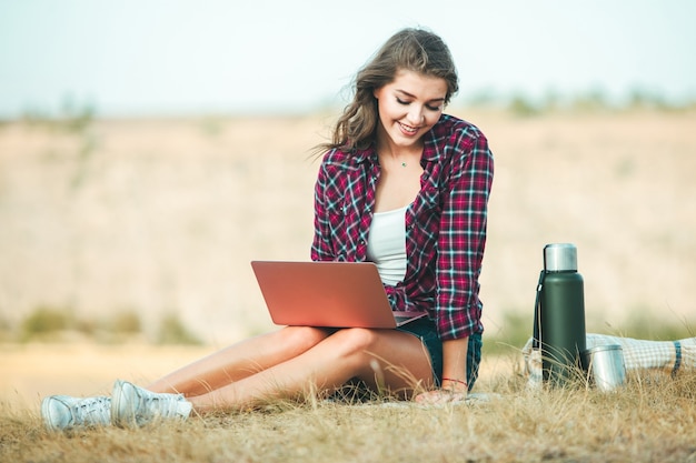 Office outdoors. Girl freelancer work typing on laptop