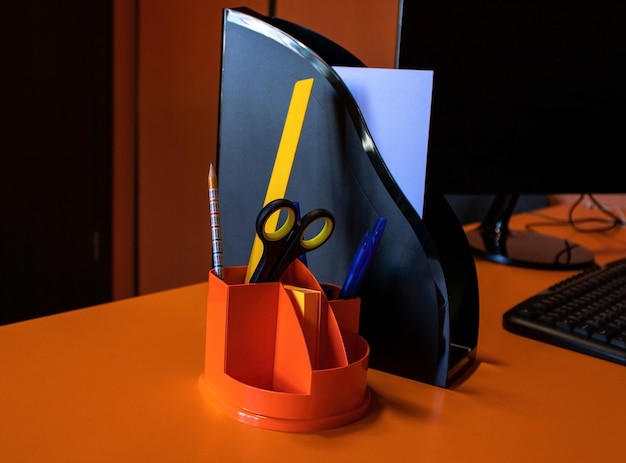 Office pen holder and vertical paper tray on the orange Desk