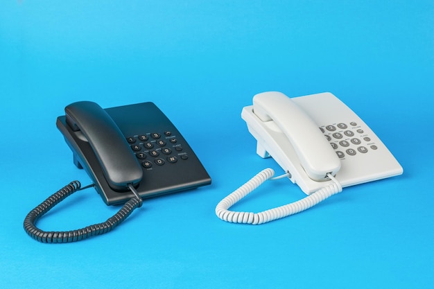 オフィスの電話は、青の背景に白と黒です。フラットレイ