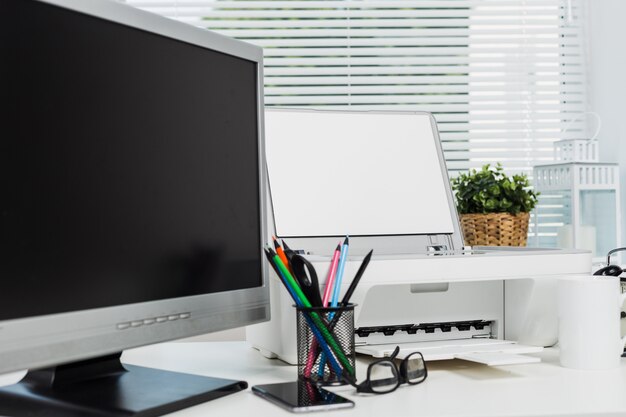 Office printer and computer on office desk, modern office equipment