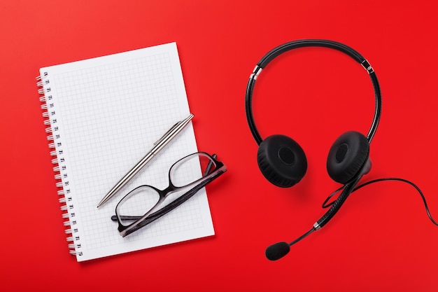 Photo office red desk with supplies and headset