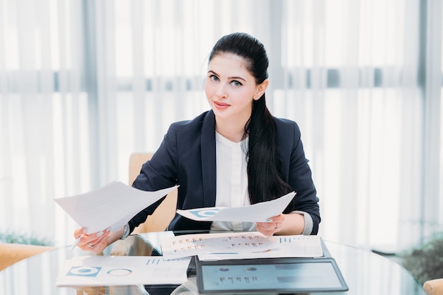 Office routine. Woman working with papers sitting at her desk