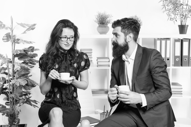 Office rumors Office coffee Couple coworkers relax coffee break Share coffee with with colleague Flirting colleagues Bearded man and attractive woman Man and woman conversation coffee time