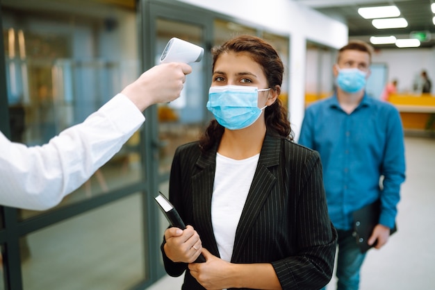 Office staff undergo temperature screening at the entrance. Business. Covid-19.