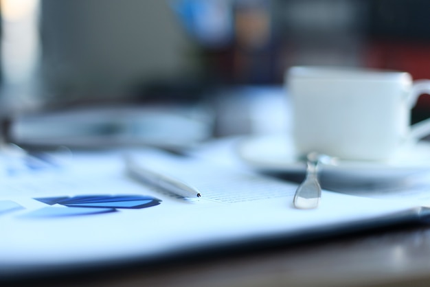 Office supplies and coffee cup on table