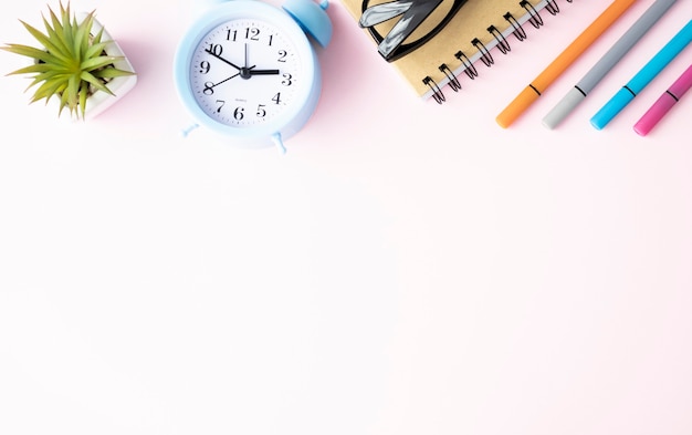 Office supplies lie on a pink background. Study at school. Rainbow color.