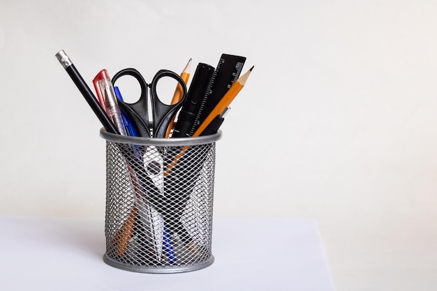 Photo office supplies in metal stand on gray background