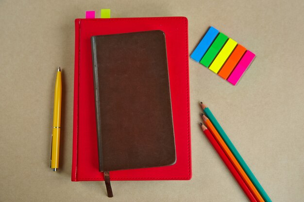 Office supplies, notebooks, pen, pencils, bookmarks, on a paper background