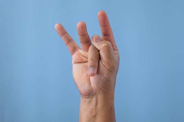 Office syndrome concept Middle finger is stretched after working Close up shot isolates on blue background Forehand view