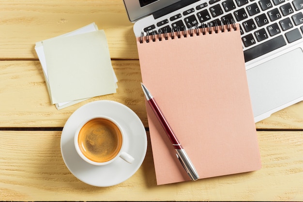 Office table background with coffee cup, pencils and computer keyboard.