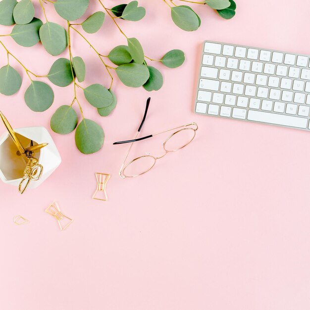 Office table desk with computer green leaves eucalyptus clipboard golden accessories diary glasses m