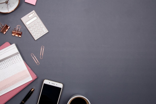 Office table desk with smartphone and other office supplies on grey background.