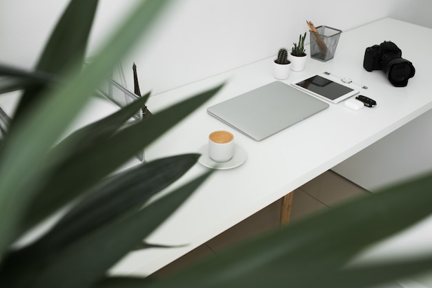 Photo office table on which laptop, coffee, tablet, camera and other items
