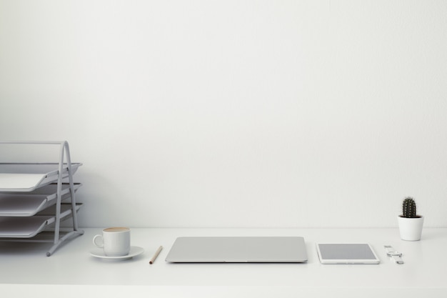 office table on which laptop, coffee, tablet,