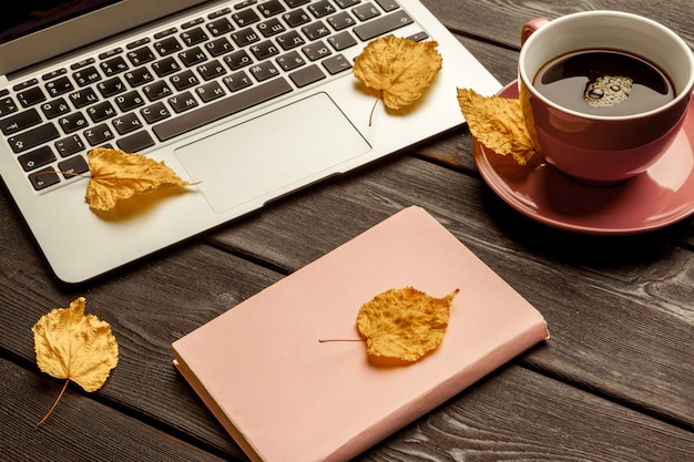 Office table with blank notebook and laptop 