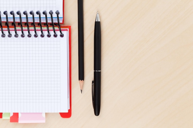 Office table with blank notepad pen and pencil