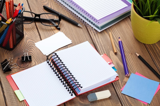 Photo office table with blank notepad and supplies