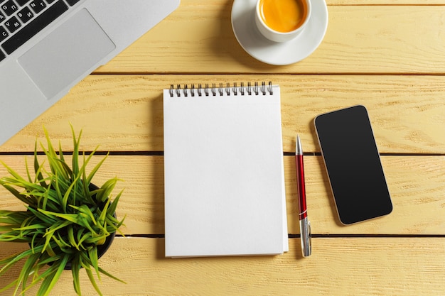 Office table with coffee cup, pencils and computer keyboard. Business workplace or workspace concept. 