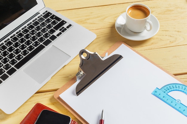 Office table with coffee cup, pencils and computer keyboard. Business workplace or workspace concept. 