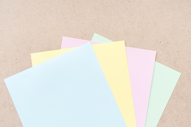 Office table with colorful paper sheets, top view