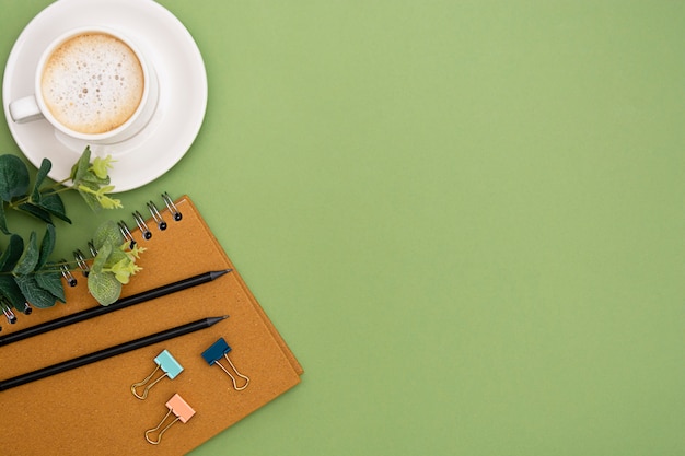 Office table with notebook and coffee cup. Table top, work space with copy space. Creative flat lay.