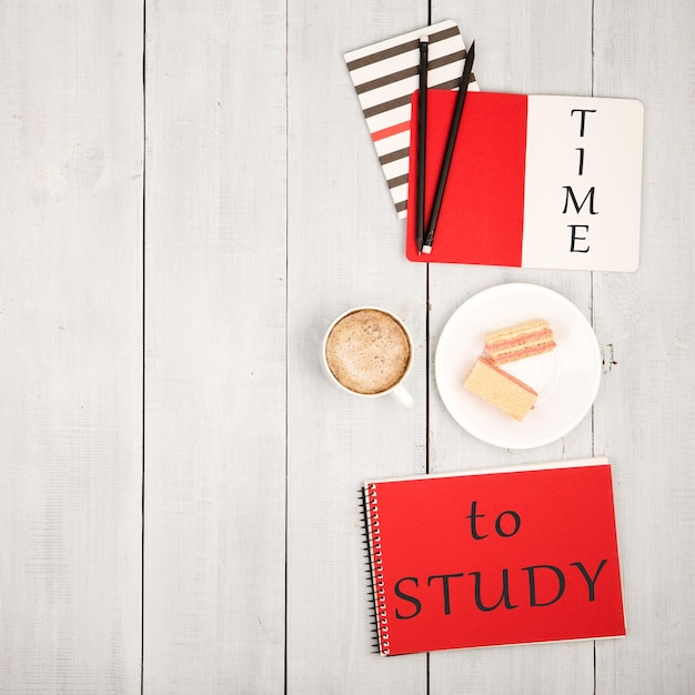 Office table with notepads and inscription TIME to STUDY cup of coffee and waffles