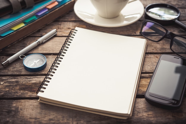 Office tafel met lege notebook en smartphone / koffiekopje