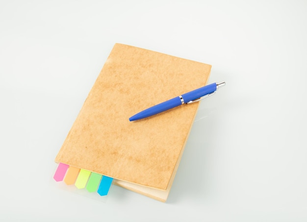 Office tools Notebook with colored bookmarks and a blue fountain pen on a light background