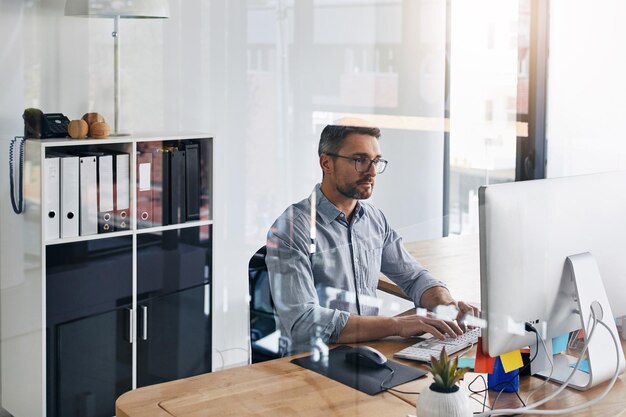 Office typing and business man on computer for online research information and website at desk Corporate professional and person on pc for programming software update and planning in workspace