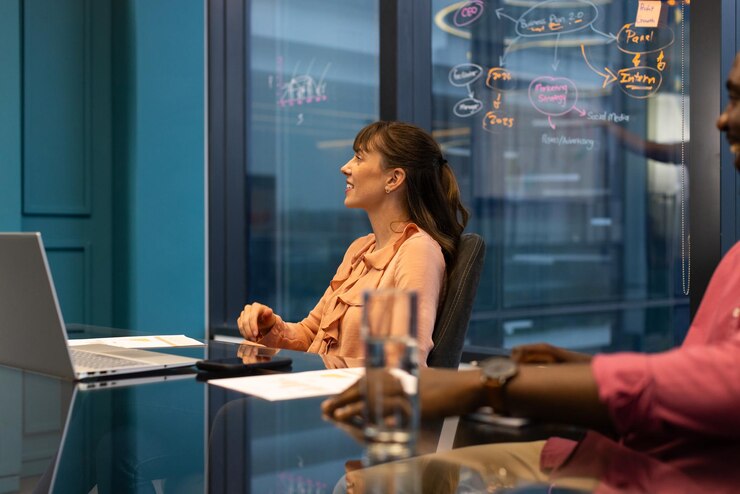 Photo in office woman participating in meeting with laptop and glass of water on table
