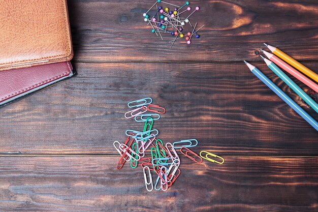 Office wooden table with colorful supplies, view from above