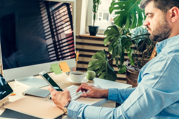 Office worker doing his job sitting at his working table with a computer