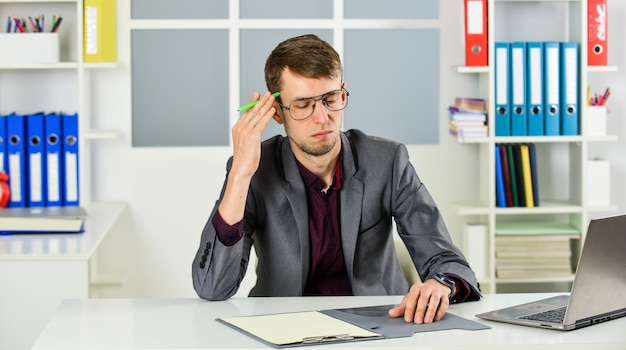 Photo office worker guy sit table laptop computer solving problem concept