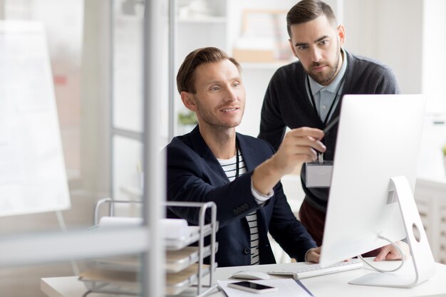 Office Worker Pointing at Computer Screen