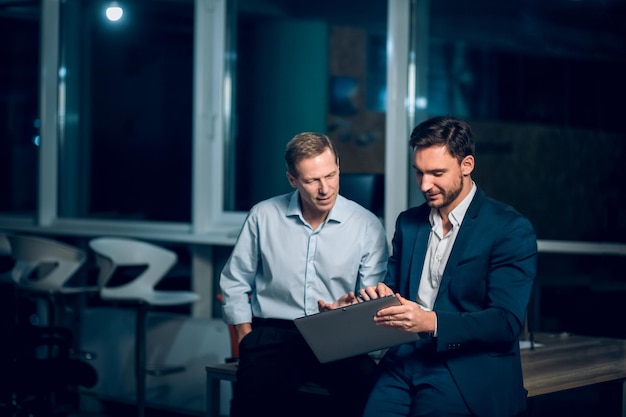 Office worker sharing his project on tablet with his colleague