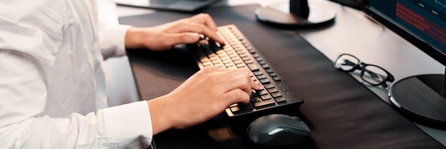 office worker sitting on workspace desk focused and engaged using computer and typing on keyboard to input data ensure accurate data management in the modern workplace trailblazing