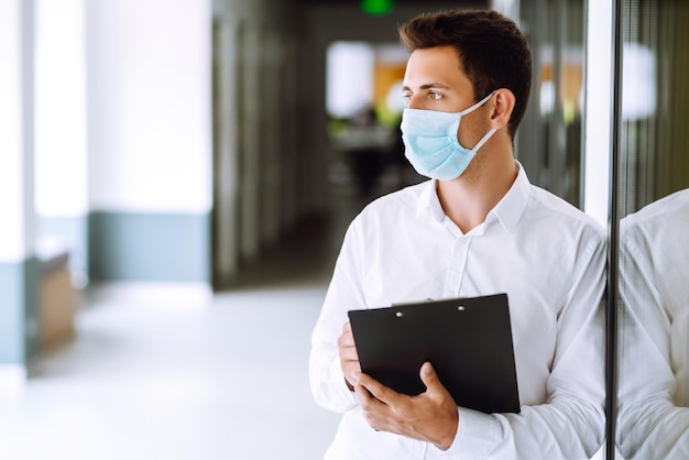 Office worker with face mask working in the office The concept of preventing the spread of epidemic