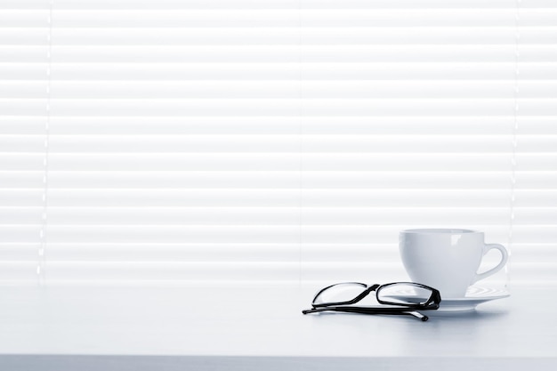 Office workplace with coffee cup and glasses