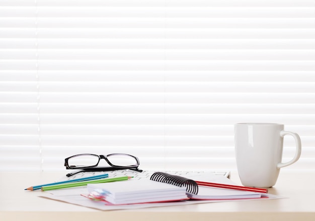 Office workplace with coffee supplies and reports